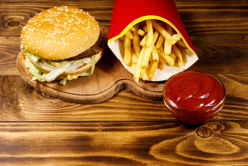 Delicious Big Hamburger With French Fries And Ketchup On Wooden Table