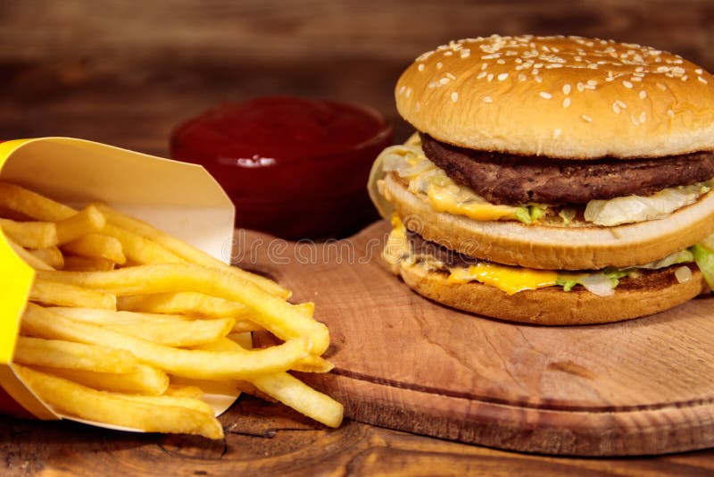 Delicious Big Hamburger With French Fries And Ketchup On Wooden Table
