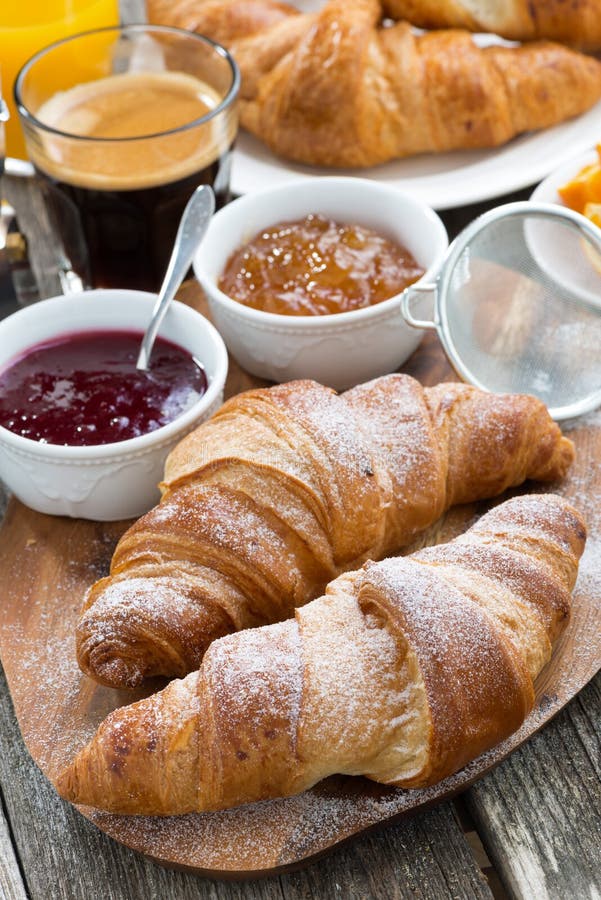 Delicious breakfast with fresh croissants on wooden table