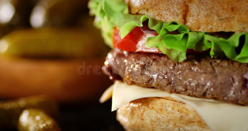 A delicious burger with beef patty rotates on the table.