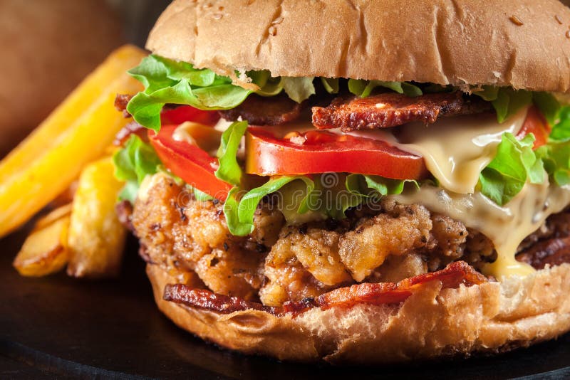 Delicious Burger with Chicken, Bacon, Tomato and Cheese Stock Image