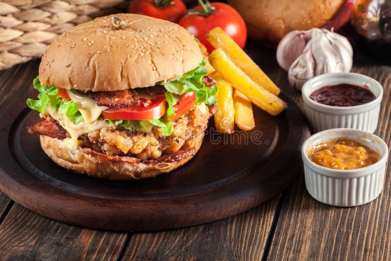 Delicious Burger with Chicken, Bacon, Tomato and Cheese Stock Photo
