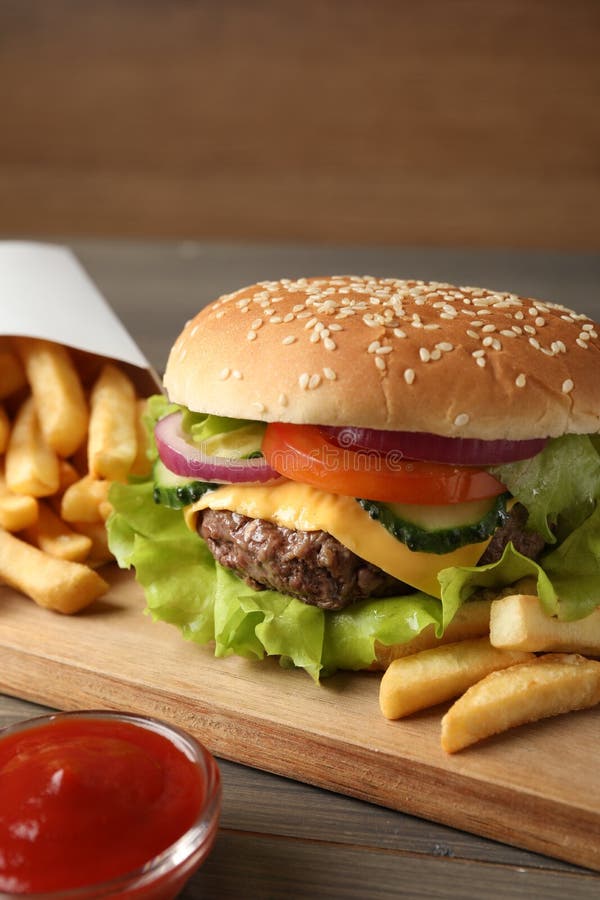 Delicious Burger Ketchup And French Fries Served On Wooden Table