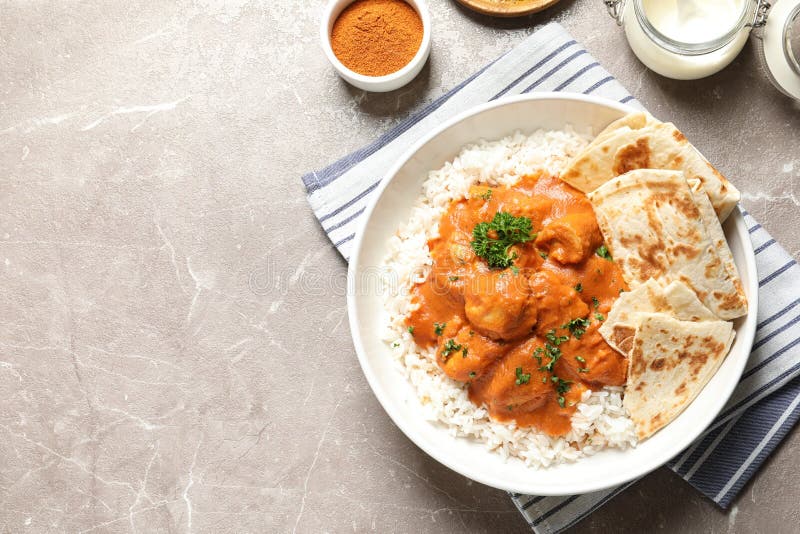 Delicious butter chicken with rice served on table, flat lay