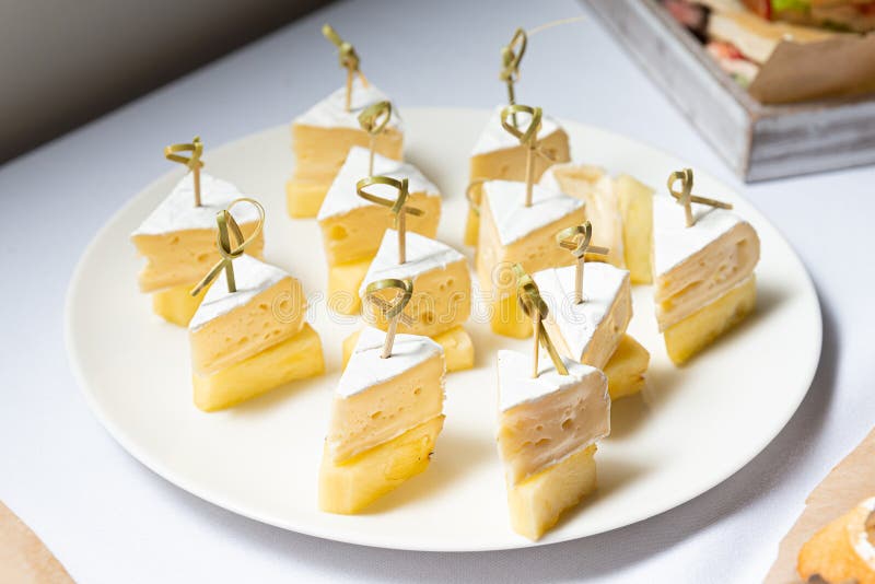 Delicious Canapes of Pineapple and Cheese. An appetizing plate of pineapple pieces and cheese canapes on skewers, perfect for any stock photo Delicious Canapes of Pineapple and Cheese. An appetizing plate of pineapple pieces and cheese canapes on skewers, perfect for any stock photo