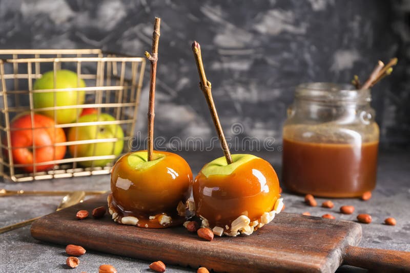 Delicious caramel apples with tree branches on wooden board stock photography