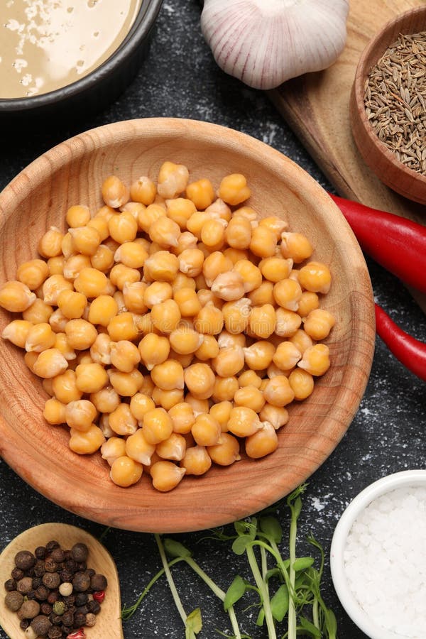 Delicious Chickpeas and Different Products on Black Textured Table
