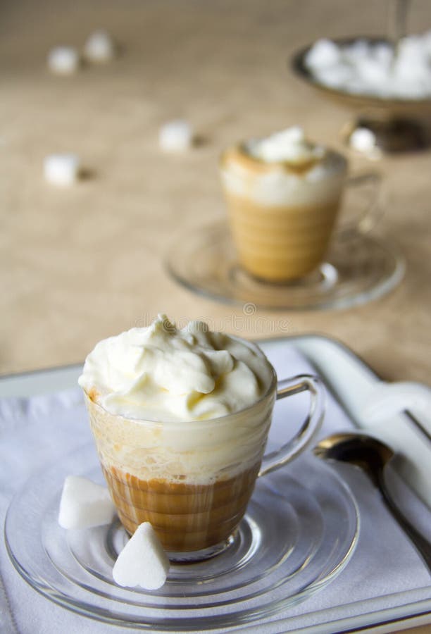 Coffee cups with cream on a yellow table cloth, selective focus