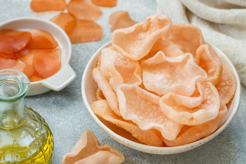 Delicious crispy chips made of starch, flour and shrimp. Bowl of Krupuk prawn crackers. Traditional Asian snack. A dish of Indonesian, Malaysian, Chinese, Korean, Japanese cuisine. Selective focus