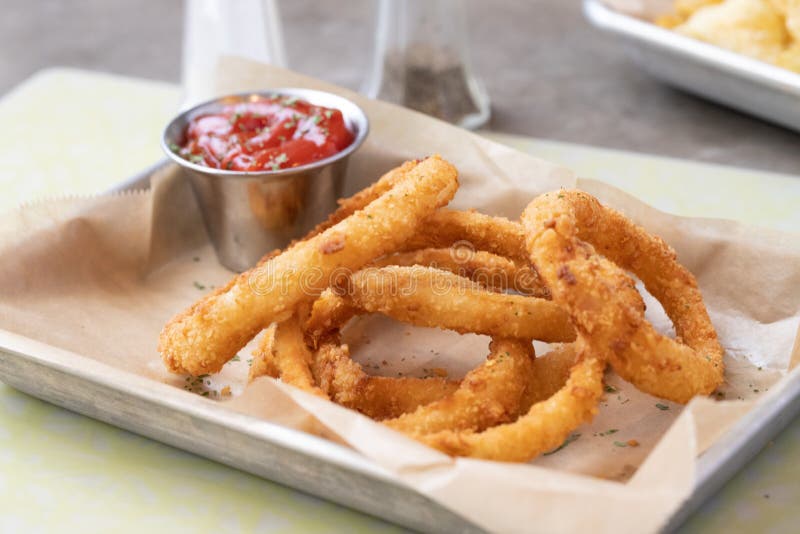 Delicious and Crispy Fried Onion Rings with Ketchup in a Container
