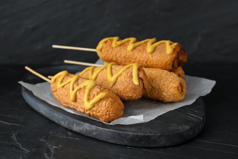 Delicious Deep Fried Corn Dogs with Mustard on Black Table Stock Image
