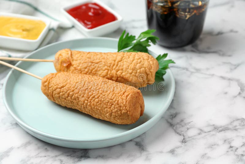 Delicious Deep Fried Corn Dogs and Sauces on White Marble Table Stock