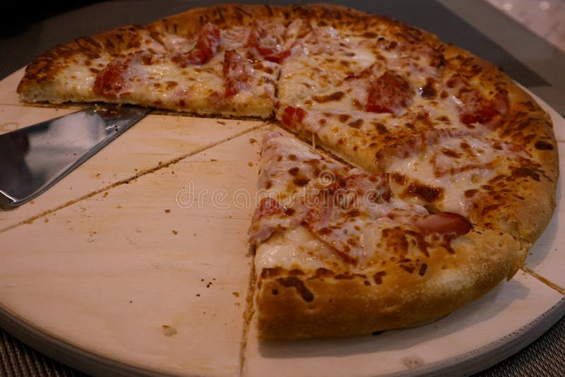 Delicious dinner, juicy pizza with cheese, tomatoes and meat on a wooden tray stock images Delicious dinner, juicy pizza with cheese, tomatoes and meat on a wooden tray stock images