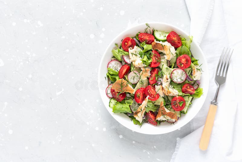 Delicious Fattoush or Arab salad with pita bread, fresh vegetables on plate. Middle Eastern bread salad. Top view stock images