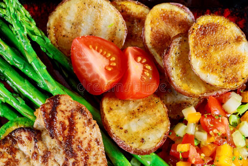 Delicious fillet chicken breast grilled with potato chips, zucchini and asparagus on top view royalty free stock photo Delicious fillet chicken breast grilled with potato chips, zucchini and asparagus on top view royalty free stock photo