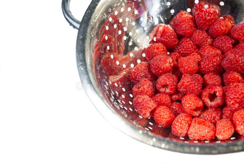 Delicious fresh and wet red raspberry in a colander for washing