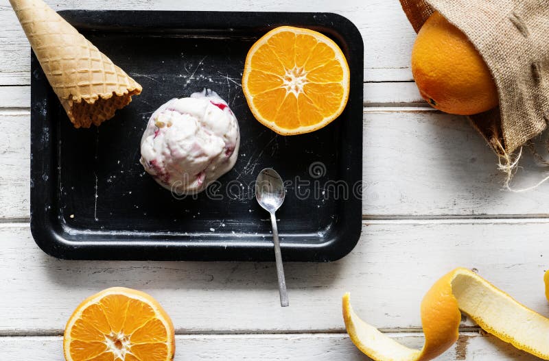 Delicious Frozen Ice Cream with Silver Spoon and Oranges on the Table