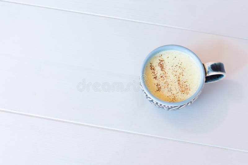 Delicious Golden Latte & x28;Turmeric Latte with Nut Milk, cinnamon, honey, ginger& x29; on white background with copyspace