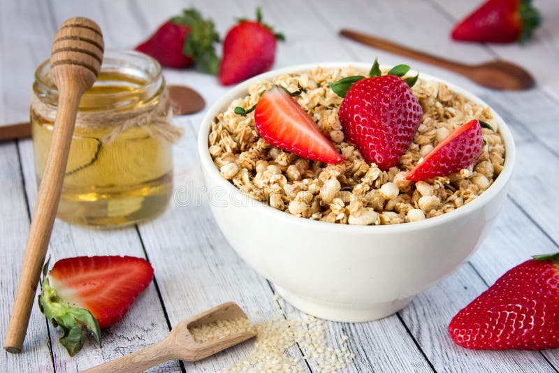 Delicious granola with fresh strawberries in a white plate with royalty free stock image
