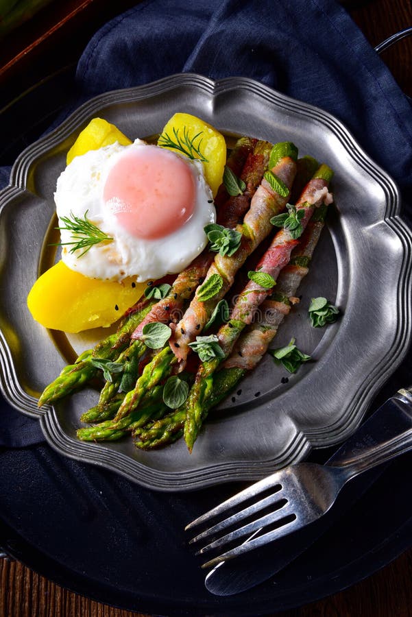 A delicious green asparagus wrapped in bacon and egg. Delicious green asparagus wrapped in bacon and egg royalty free stock photo A delicious green asparagus wrapped in bacon and egg. Delicious green asparagus wrapped in bacon and egg royalty free stock photo