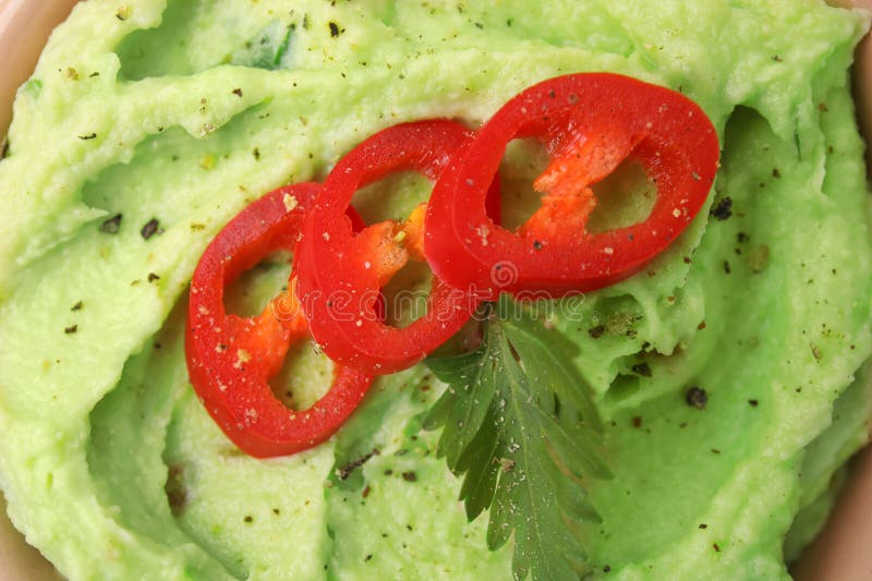 Delicious guacamole with chili pepper and parsley as background, top view stock photos