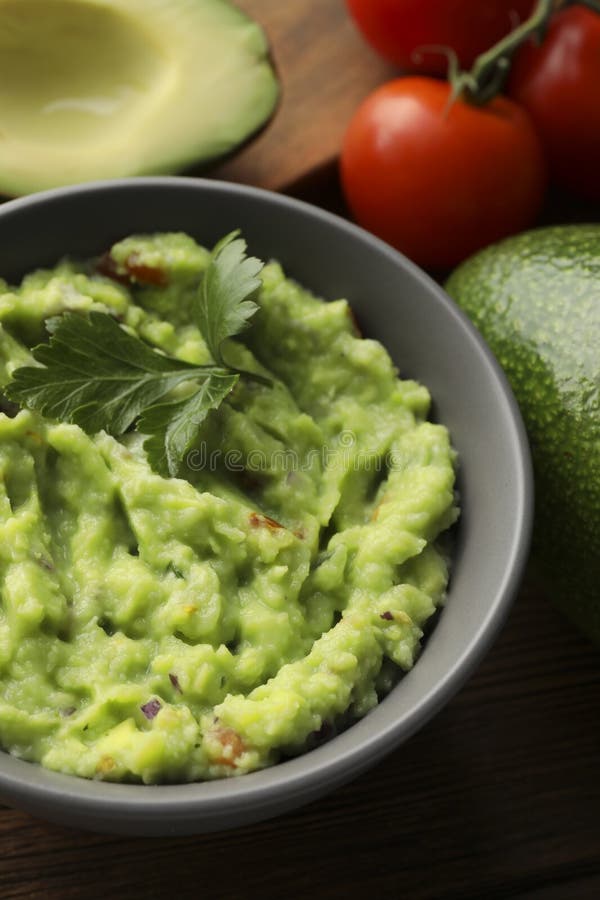 Delicious guacamole and different ingredients on table, closeup stock photography
