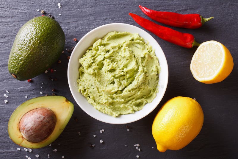Delicious guacamole sauce and ingredients. horizontal top view royalty free stock photo