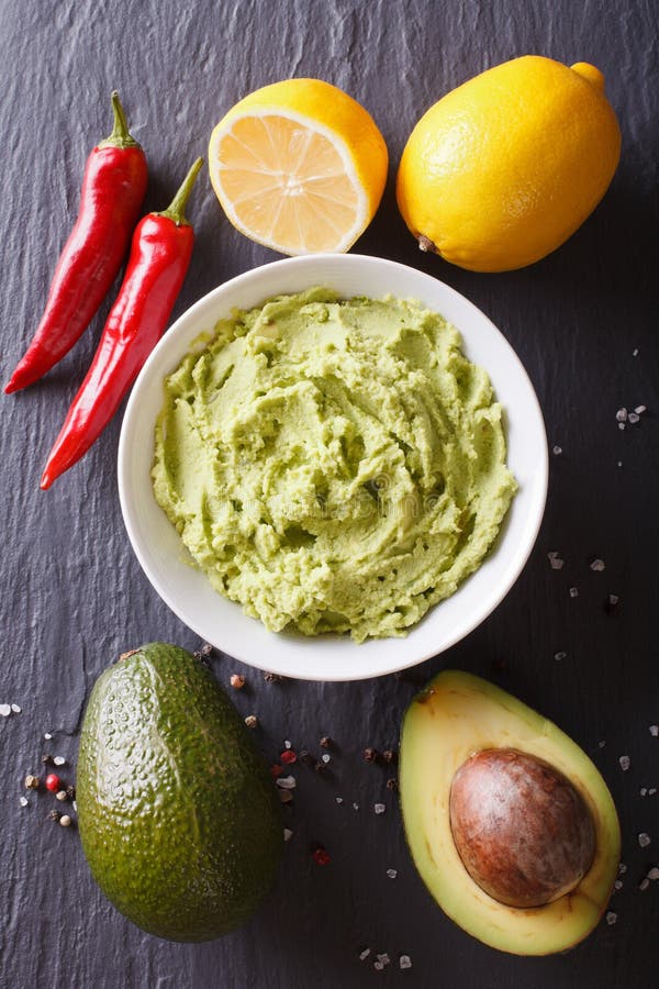 Delicious guacamole sauce and ingredients. vertical top view royalty free stock image