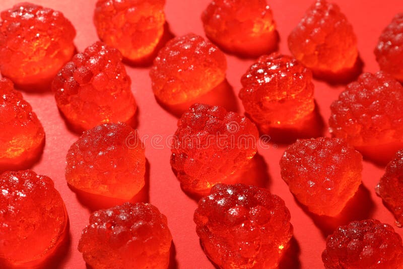 Delicious gummy raspberry candies on red background, closeup