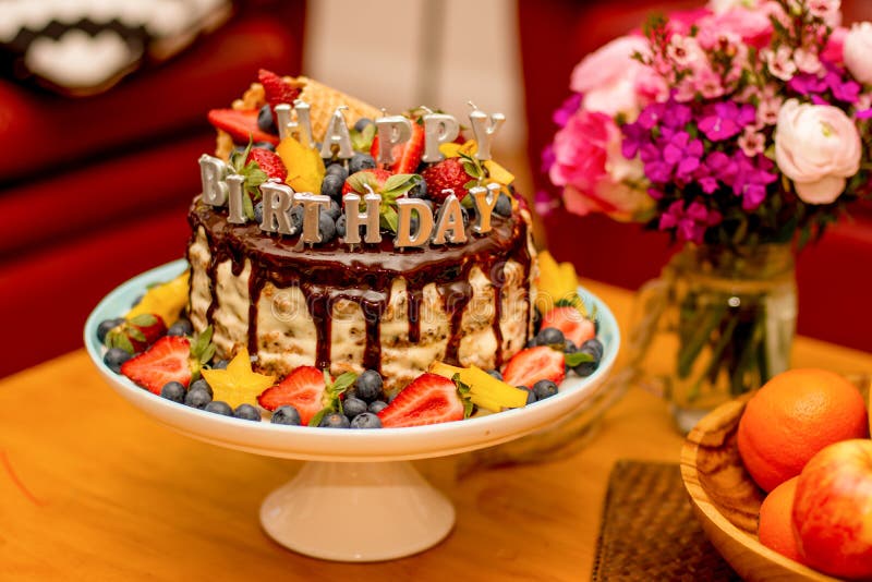 Delicious handmade layered cake decorated with Happy birthdays candles