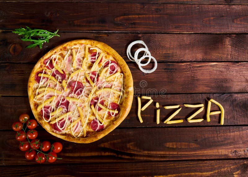 Delicious Italian pizza with French fries on a wooden table stock photography Delicious Italian pizza with French fries on a wooden table stock photography