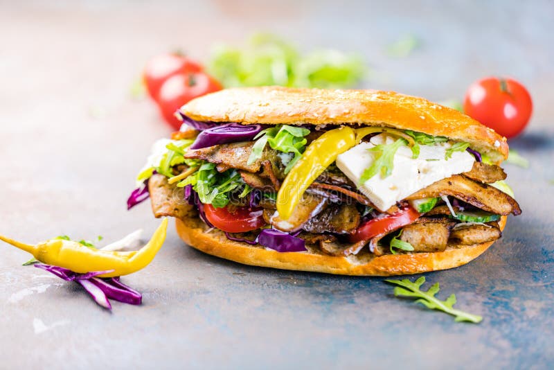 Kebab Sandwich on a grey background with salad and tomatos