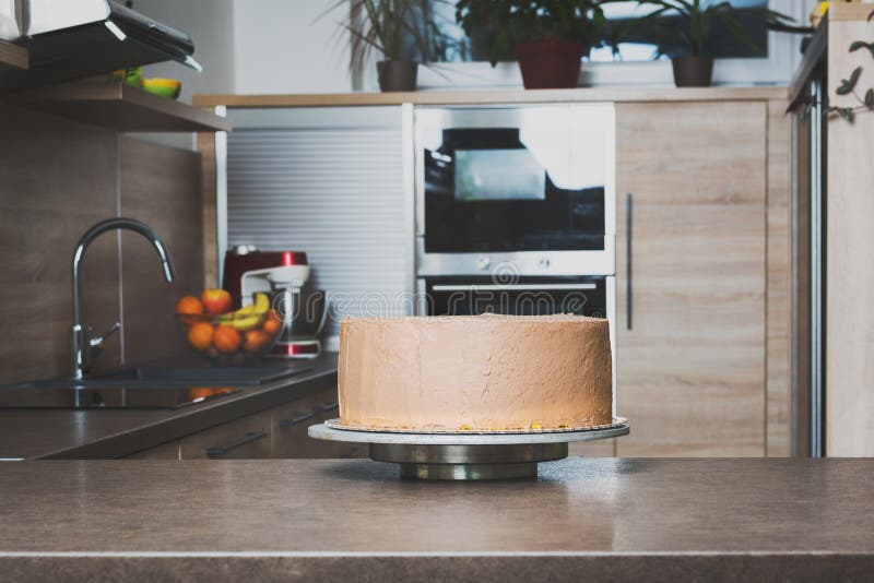 Delicious layered cake with chocolate icing cream on kitchen counter top stock photography