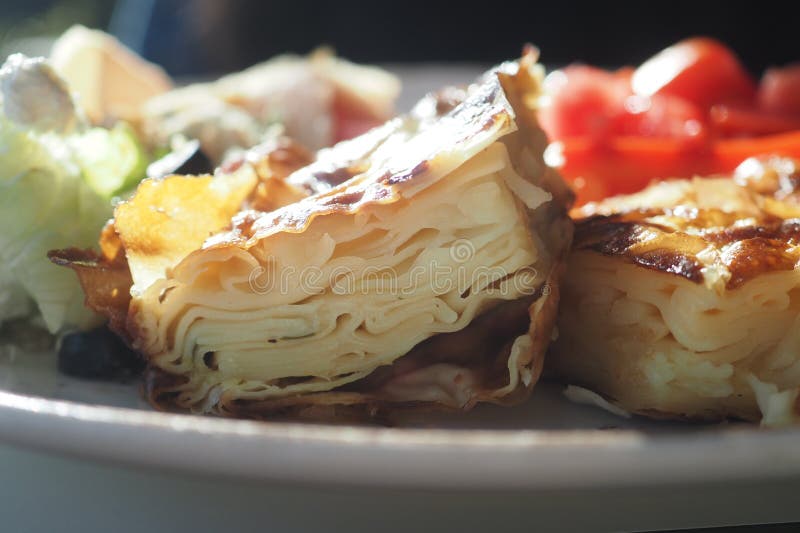 Delicious layered turkish borek served with fresh vegetables stock images