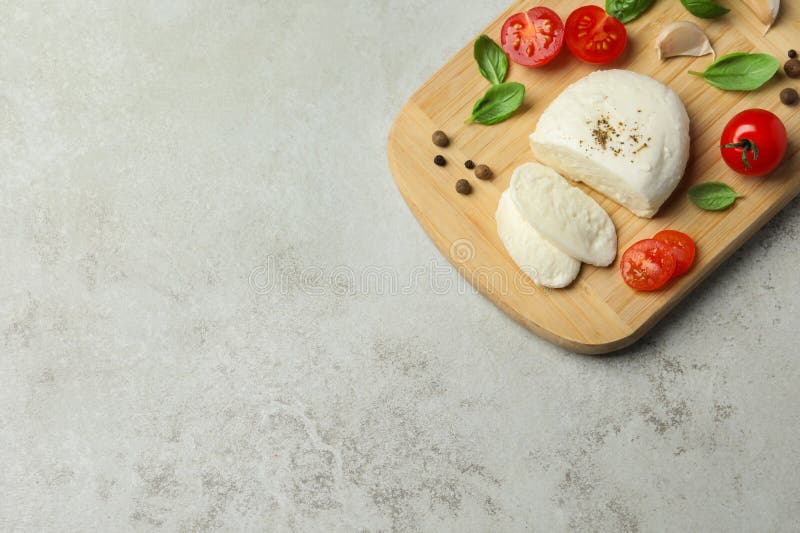 Delicious Mozzarella with Tomatoes and Basil Leaves on Light Gray Table, Top View. Space for