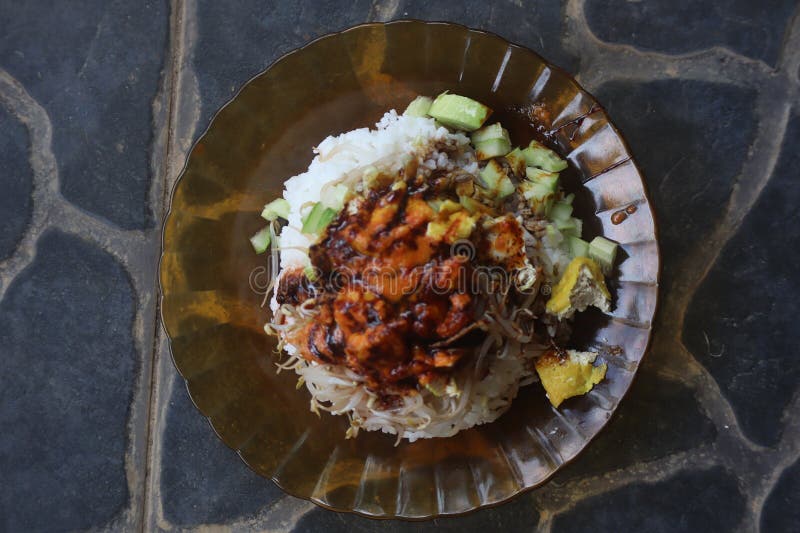 A delicious plate of rice with soy sauce seasoned chicken, tofu, bean sprouts and appetizing cucumber slices. royalty free stock image