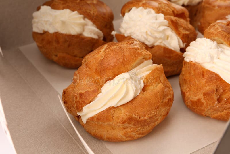Delicious Profiteroles with Cream Filling on Table, Closeup Stock Photo