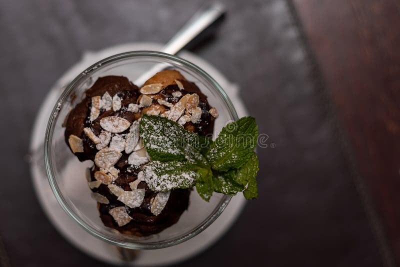 Delicious profiteroles desser sprinkled with nuts and powdered sugar. Close-up.