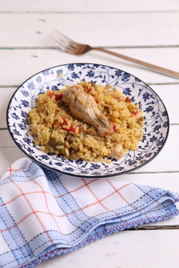 Delicious Rice Dish with Chicken Drumstick on the Plate on the Wooden