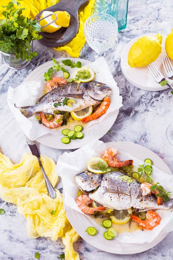 Delicious roasted dorado or sea bream fish with lemon and fresh Prawns stock images Delicious roasted dorado or sea bream fish with lemon and fresh Prawns stock images