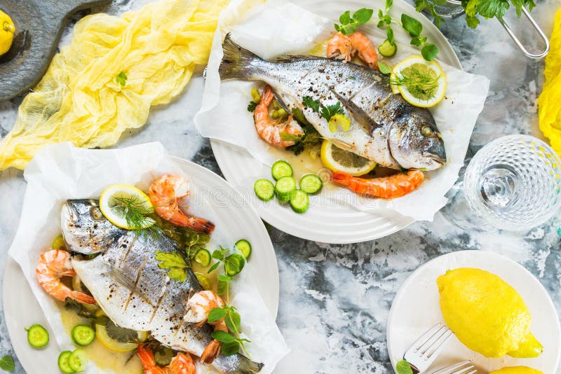 Delicious roasted dorado or sea bream fish with lemon and fresh Prawns stock photo Delicious roasted dorado or sea bream fish with lemon and fresh Prawns stock photo