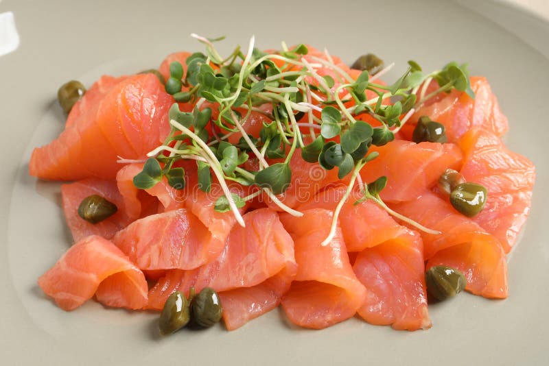 Delicious Salmon Carpaccio with Capers and Microgreens on Plate