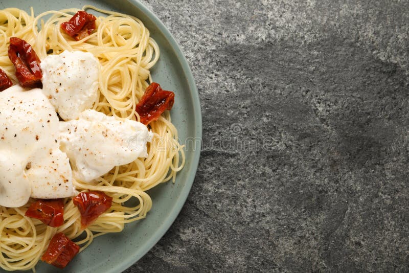 Delicious Spaghetti with Burrata Cheese and Sun Dried Tomatoes on Grey