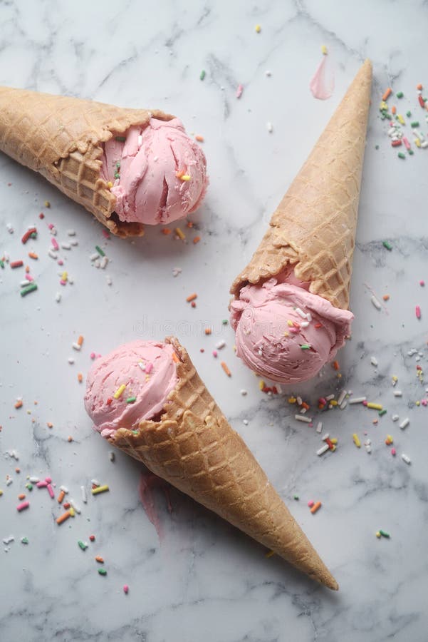 https://thumbs.dreamstime.com/b/delicious-strawberry-ice-cream-cone-decorated-sugar-rainbow-sprinkles-marble-background-top-view-150629374.jpg