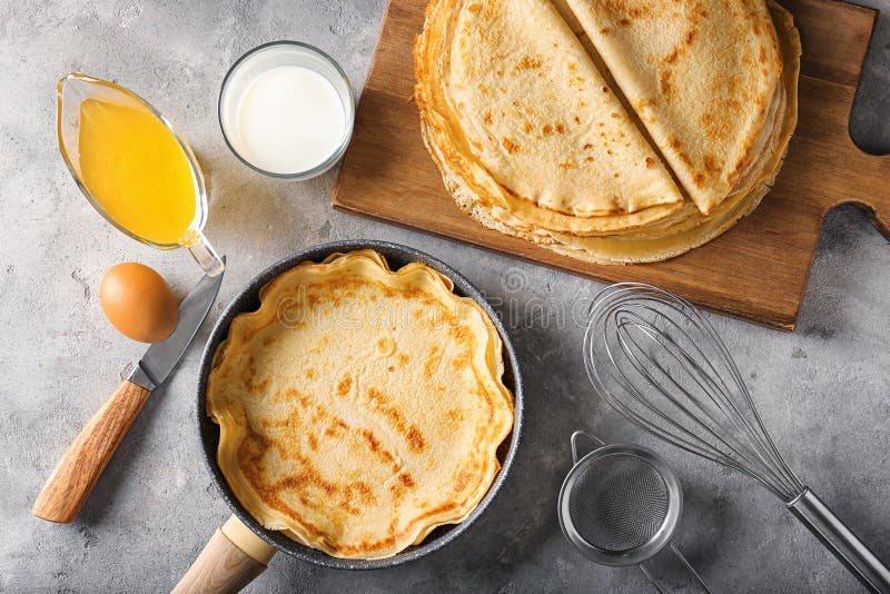 Delicious thin pancakes with glass of milk and honey on grunge table stock images Delicious thin pancakes with glass of milk and honey on grunge table stock images