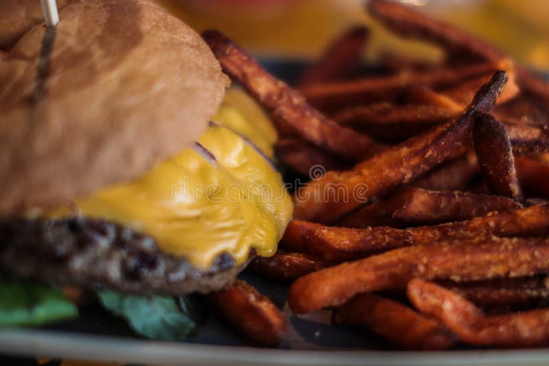 Deliciouse cheeseburger z świeżymi batatów dłoniakami fotografia royalty free Deliciouse cheeseburger z świeżymi batatów dłoniakami fotografia royalty free