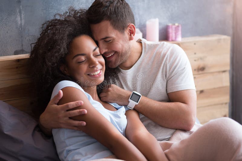 Delighted Couple Hugging Each Other In Bed Stock Image