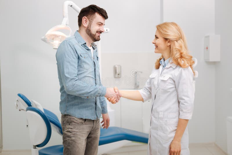 Delighted happy guy saying thanks to his dentist stock photography Delighted happy guy saying thanks to his dentist stock photography