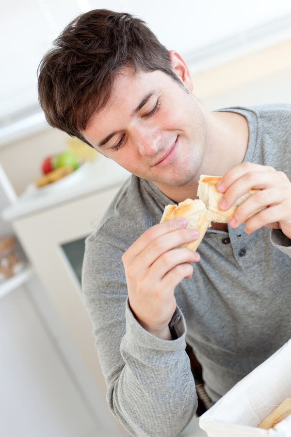 Delighted Man Eating Bread in the Kitchen Stock Photo Image of