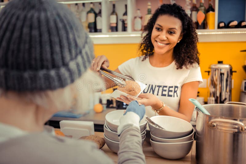 Delighted nice woman giving a fresh bun